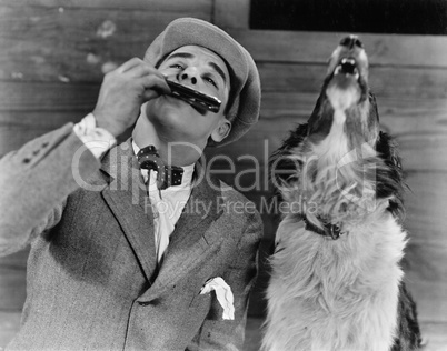 Man playing harmonica with howling dog