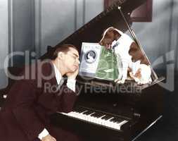 Man asleep at piano with dog
