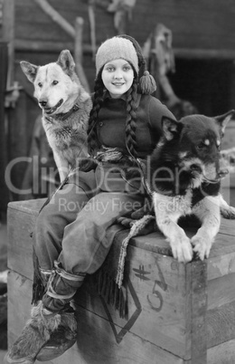 Woman posing with two sled dogs