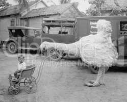 Fake ostrich pushing boy in stroller