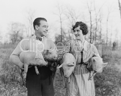 Couple carrying pigs