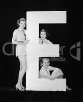 Women posing with huge letter E
