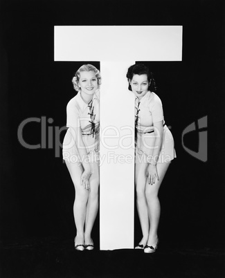 Women posing with huge letter T