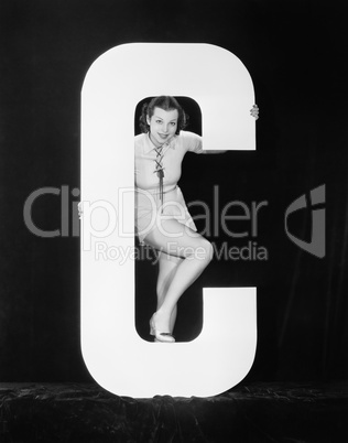 Woman posing with huge letter C