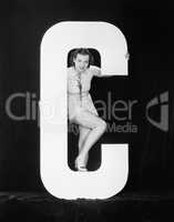 Woman posing with huge letter C