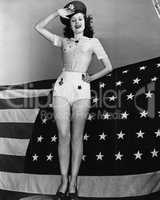 Portrait of woman saluting with American flag