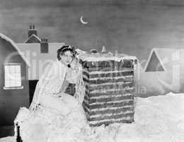 Young woman listening at chimney on snowy roof