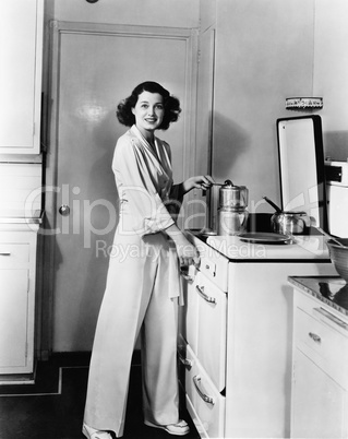 Portrait of woman at stove in kitchen