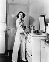 Portrait of woman at stove in kitchen