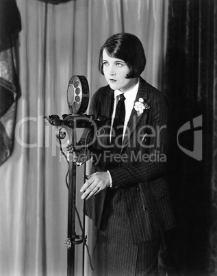 Woman in suit at microphone
