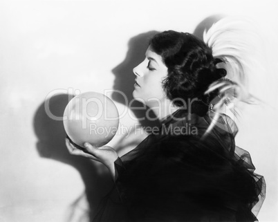 Profile of dramatic woman holding sphere