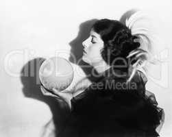 Profile of dramatic woman holding sphere