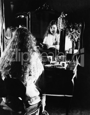 Woman at dressing table looking in mirror