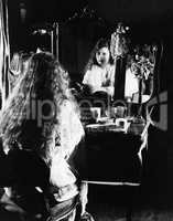 Woman at dressing table looking in mirror