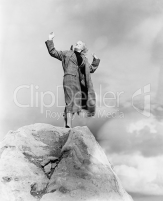 Woman atop rock on windy day