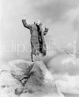 Woman atop rock on windy day