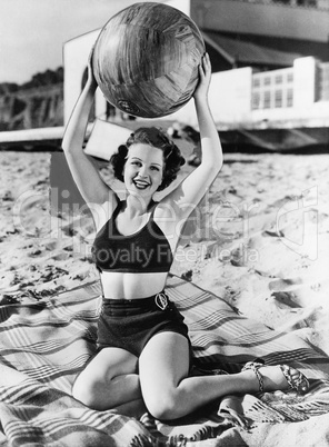 Portrait of woman with ball at beach