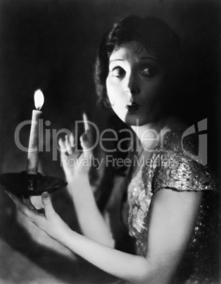 Portrait of fearful woman with candle