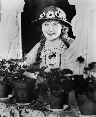 Portrait of woman in window with flower pots