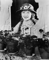 Portrait of woman in window with flower pots