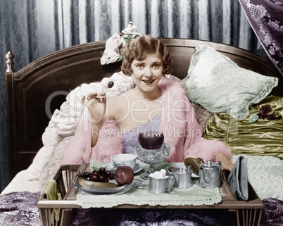 Woman eating breakfast in bed