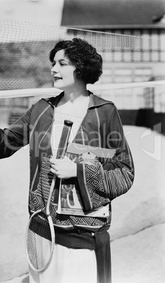 Portrait of woman with badminton racket and magazine