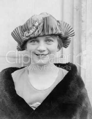 Portrait of young woman in hat and fur coat