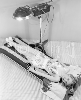 Portrait of woman under tanning lamp