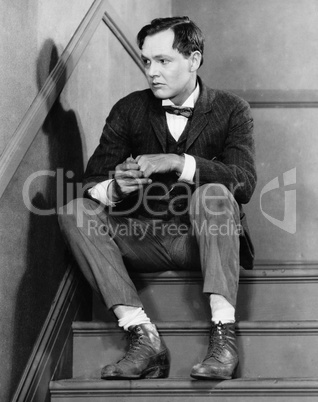 Portrait of troubled man sitting on stairs