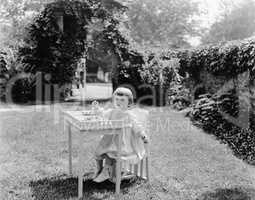 Toddler eating at table in garden