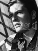 Portrait of young man with shadow of bars