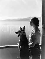 Woman and dog looking out over water