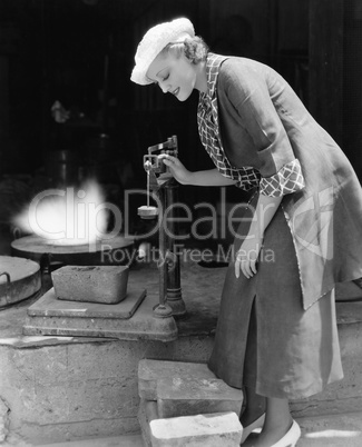 Woman weighing silver outside foundry