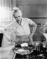 Woman flipping eggs on stove