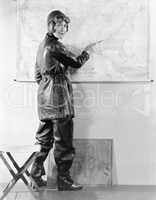 Young woman pointing at a map in a motorcycle outfit