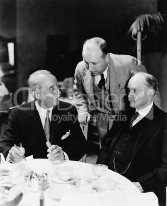 Three men sitting together at a table