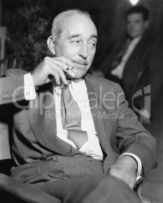 Elegant man sitting and smoking a cigarette