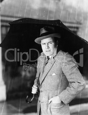 Man with an umbrella standing in the rain