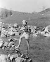 Young woman hiking through a stream of water