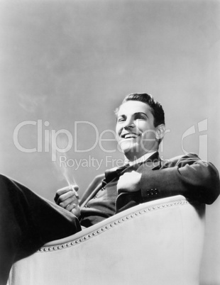 Man sitting in an arm chair smoking