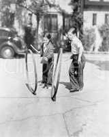 Boy and girl playing hoop and stick on a sidewalk