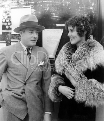 Woman in a fur coat having a conversation with a man