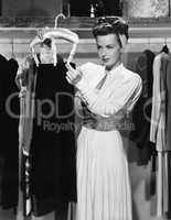 Young woman hanging up a skirt in the closet