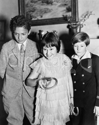 Three children standing together playing a game
