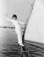 Young girl standing on a sailboat and waving