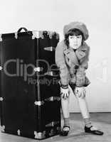 Girl standing next to suitcase