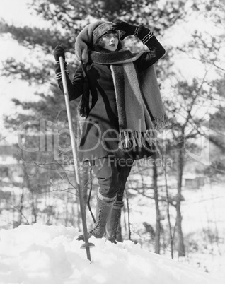 Young woman hikes through snow covered woods