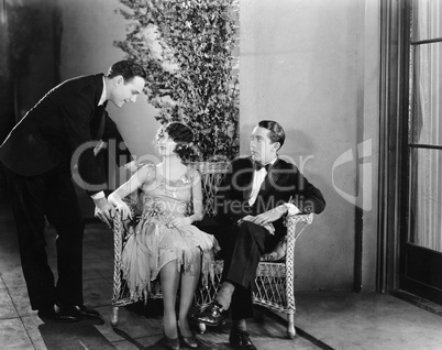 Man greeting a couple sitting on a bench