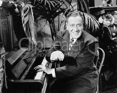 Man sitting next to a piano