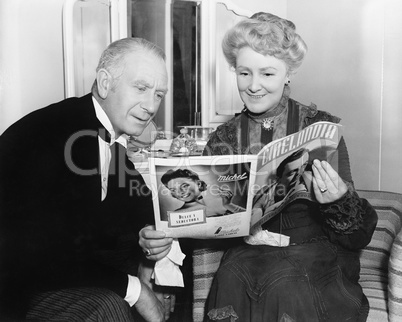 Couple sitting together and looking at a magazine